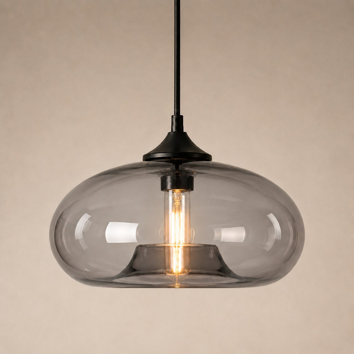 Farbige Glas-Pendelleuchte in Grau auf warmem neutralem Studiohintergrund