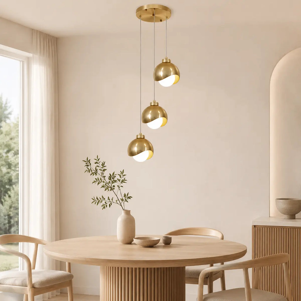 Goldene 3-flammige Glaskugel-Pendelleuchte in einem modernen Esszimmer