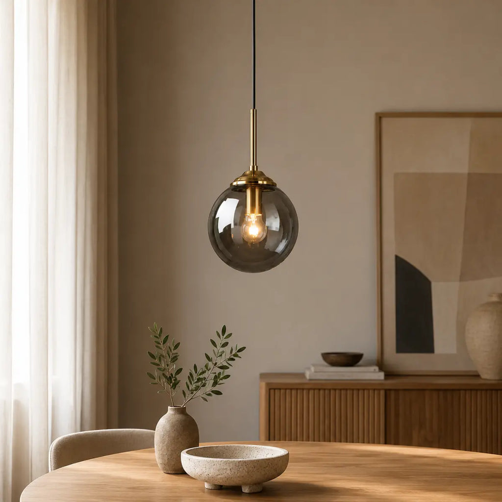 Graue Glaskugel-Pendelleuchte über einem Holztisch im modernen Esszimmer