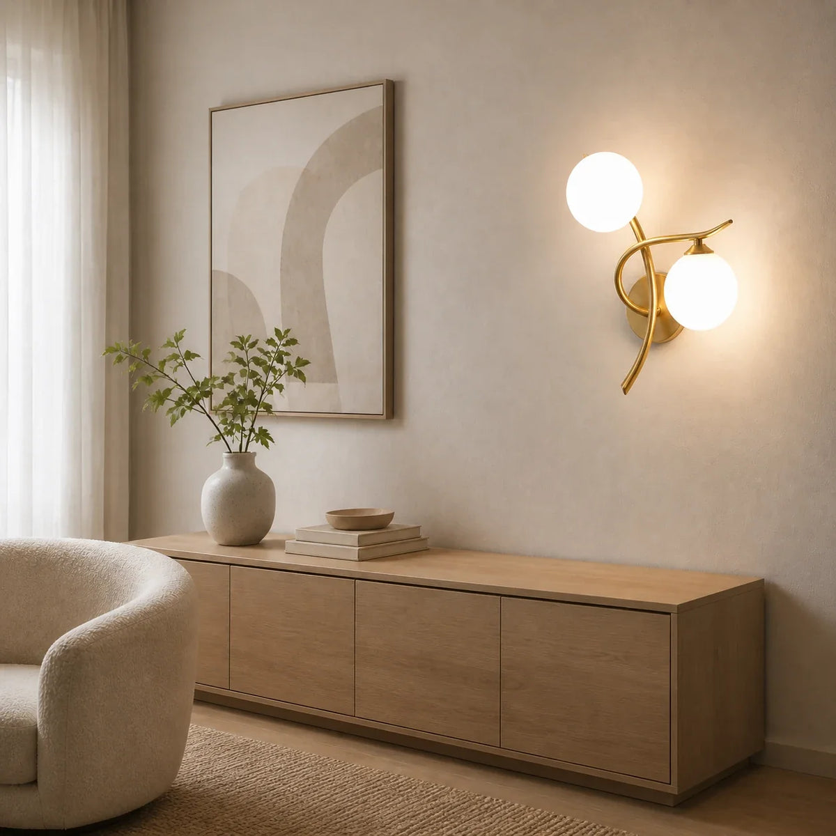 Goldene Glasball-Wandleuchte mit zwei Glaskugeln an einer hellen Wohnzimmerwand