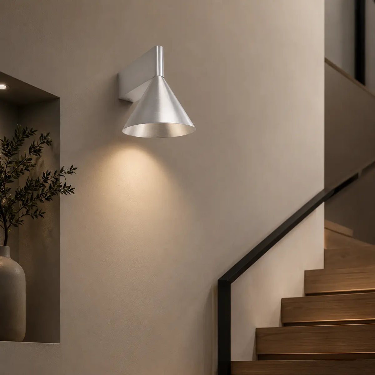 Silberne konische Aluminium-Wandleuchte an einer Treppe