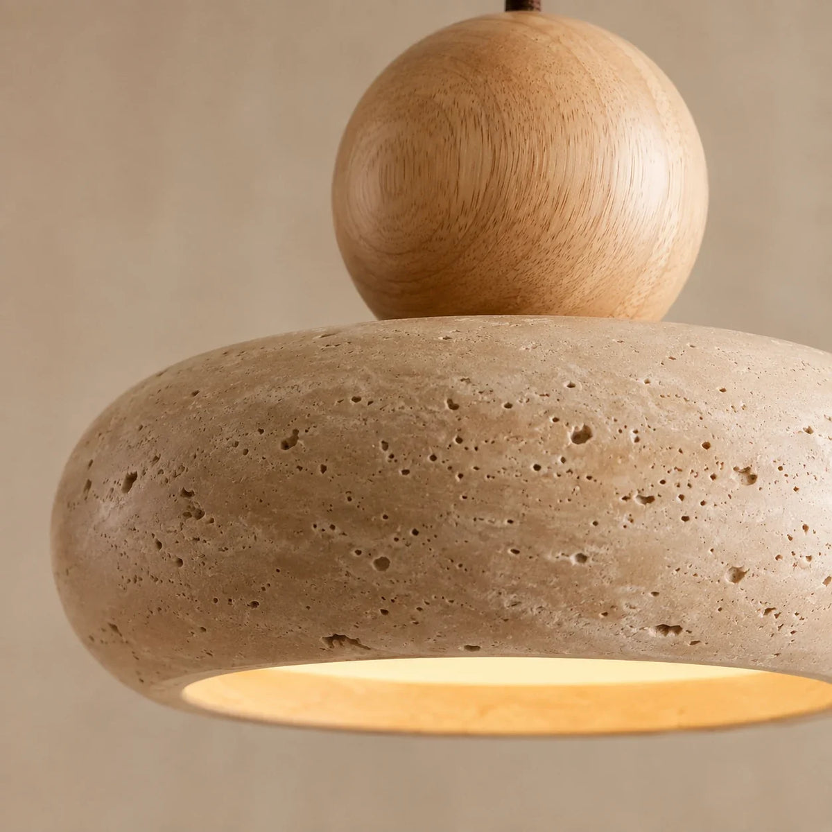Detailansicht der porösen Natursteinoberfläche und Holzkugel einer Pendelleuchte