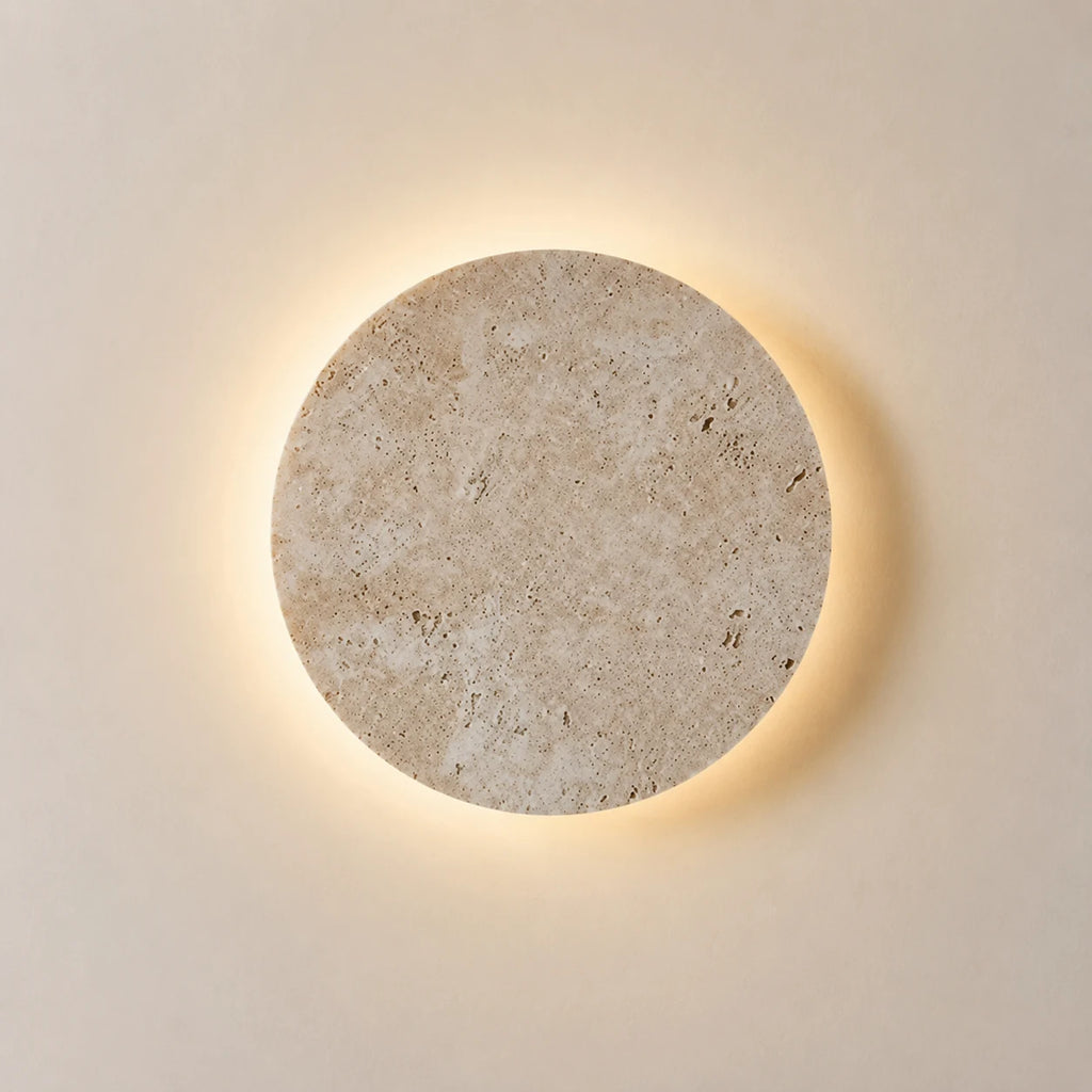 Runde Travertin-Wandleuchte mit indirektem Licht auf hellem Hintergrund
