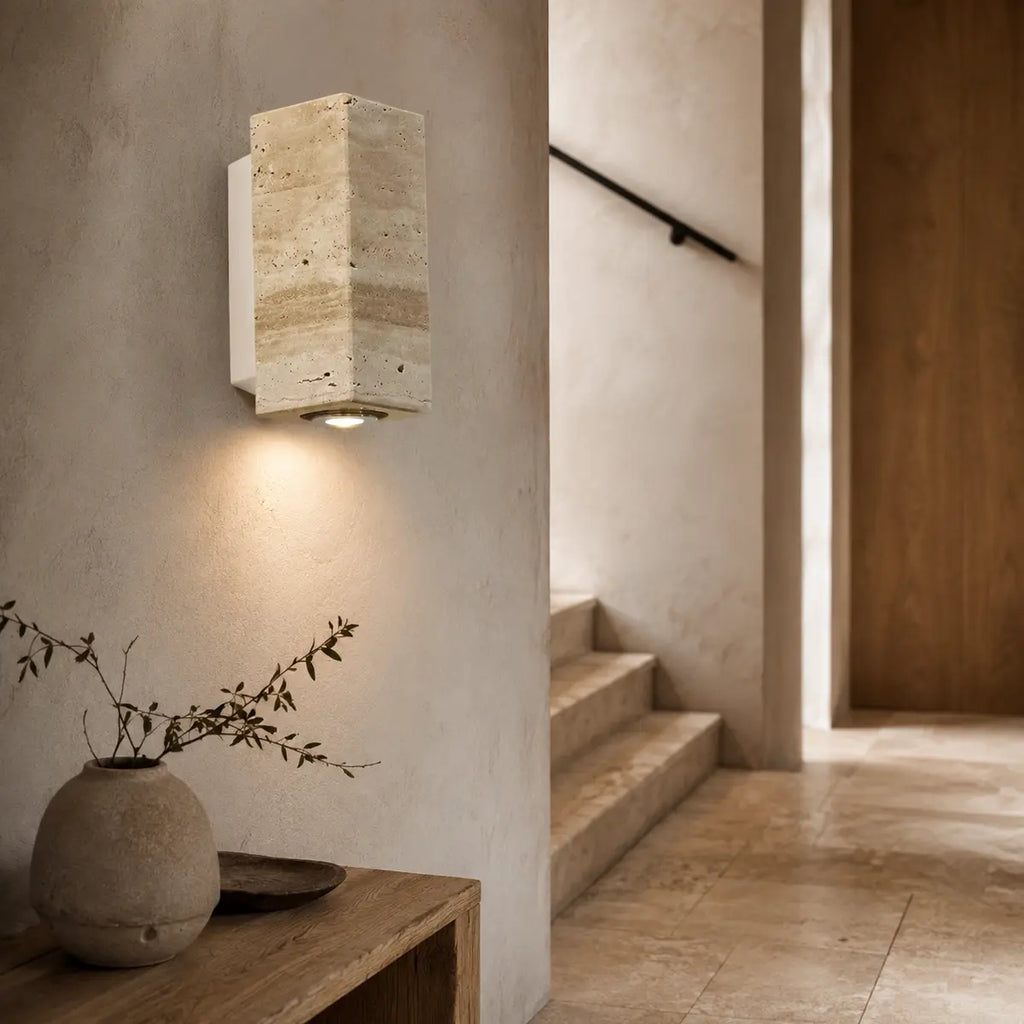 Quadratische Marmor-Wandleuchte mit Metallrückwand im warmen Flur neben einer Treppe
